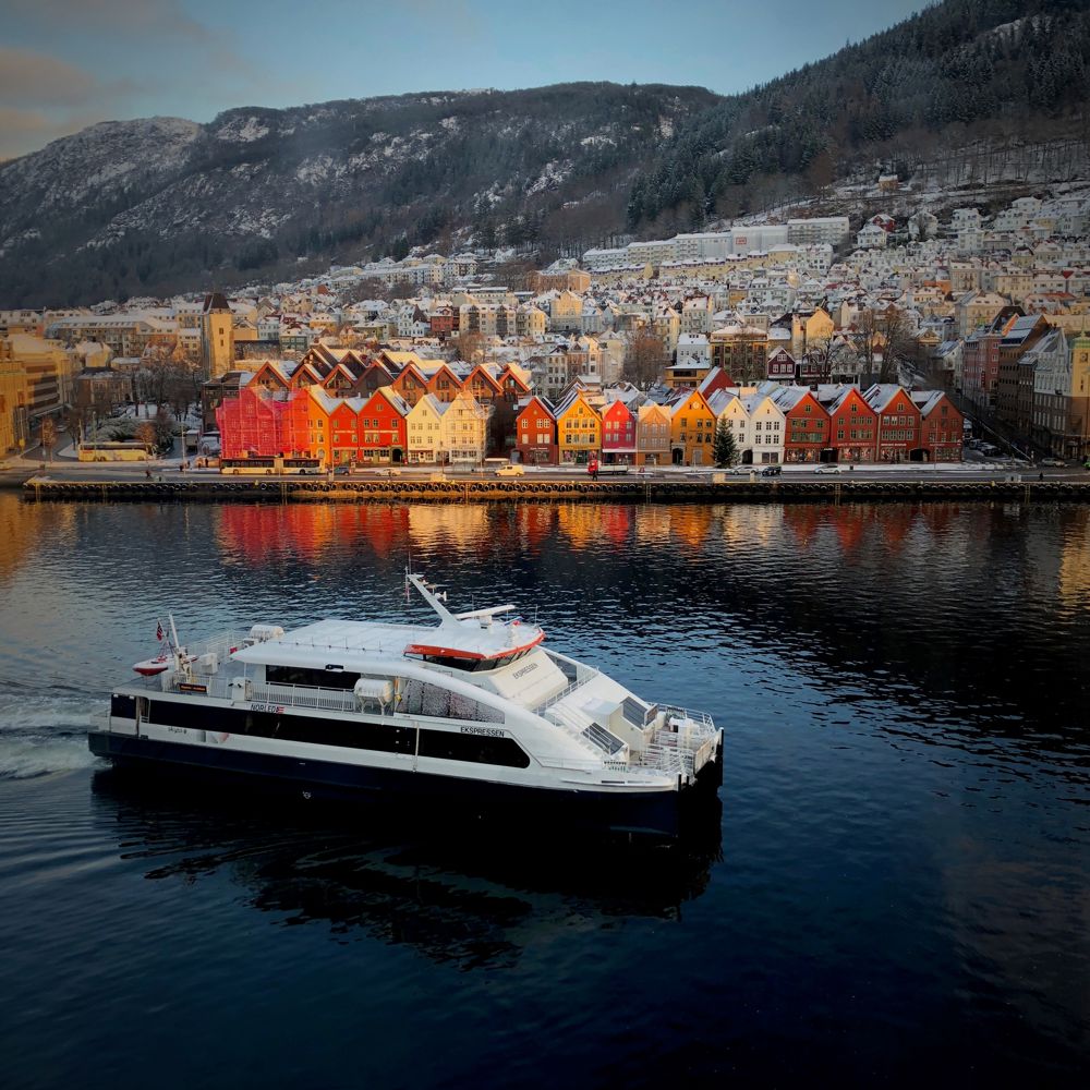 Båten Ekspressen på veg inn til Strandkaiterminalen i Bergen. Viser Bryggen i bakgrunnen.